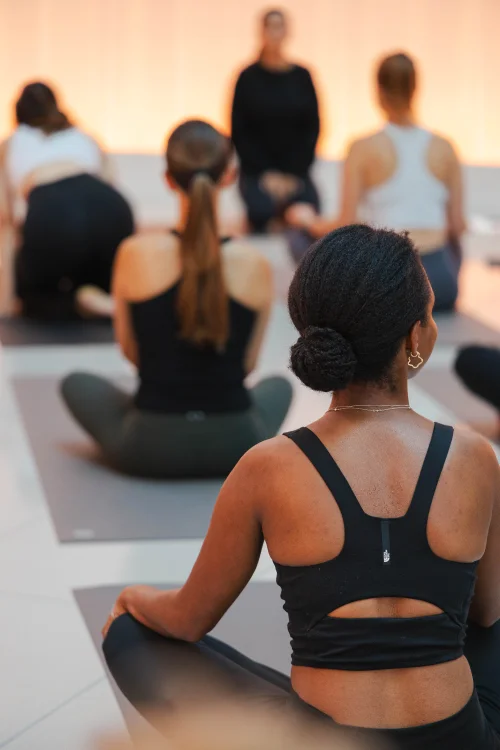 Teilnehmerinnen bei einer gemeinsamen Yogastunde auf Yogamatten.